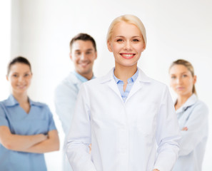 smiling female doctor with group of medics