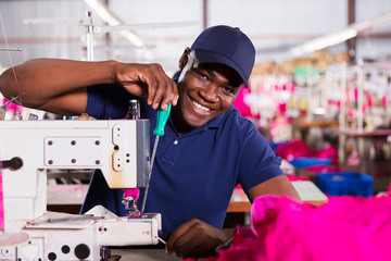 african american mechanic working in clothing factory