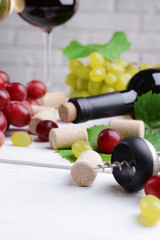 Wine bottle corks with grapes on table close-up