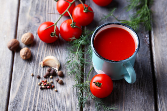 Homemade tomato juice in color mug, spices and fresh tomatoes