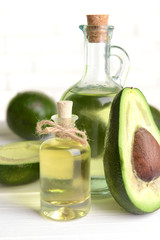 Avocado oil on table on light background