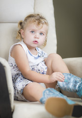Fototapeta premium Blonde Haired Blue Eyed Little Girl Putting on Cowboy Boots