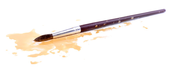 Brush and spilled paint isolated on white