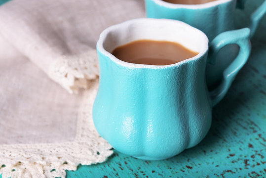 Cups of coffee with napkin on wooden table