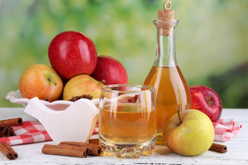 Apple cider  in bottle  with cinnamon sticks and fresh apples