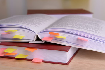 Books with bookmarks on table on bright background