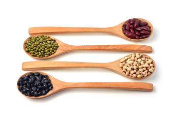 Green beans, black beans, red beans in wooden spoon, white backg