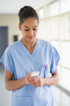 Female nurse text messaging with a mobile phone