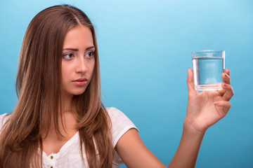 Portrait of young beautiful girl holding a glass with clean wate