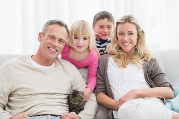 Happy family sitting with pet kitten together