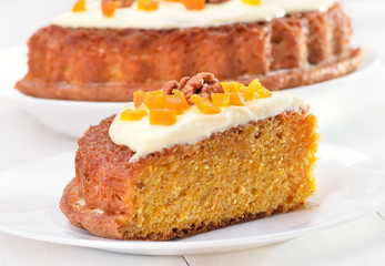 Piece of carrot pie with icing on white plate