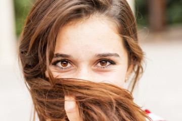 Closeup portrait of happy young woman covers her face of hair.