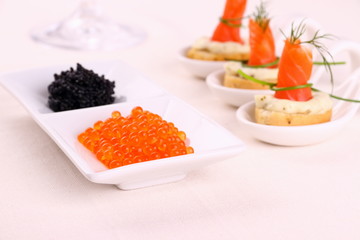 Red caviar, smoked salmon rolls on white bread