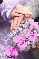 Hands with wedding rings and fower bouquet