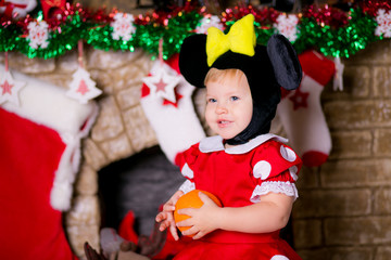 happy little girl in a New Year's suit near a Christmas tree
