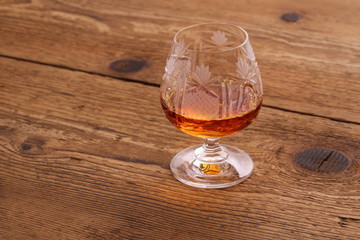 Luxure Cognac in decorated crystal glass on wood