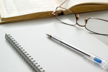 notebook with glasses and pen on table