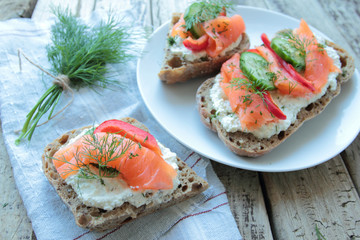 Bread with salmon and fresh vegetables on a plate