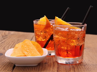 Spritz-Aperitif - zwei Orangen-Cocktails mit Eiswürfeln, Chips