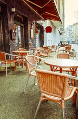 Street view of a coffee terrace with tables and chairs