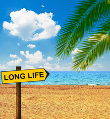 Tropical beach and direction board saying LONG LIFE