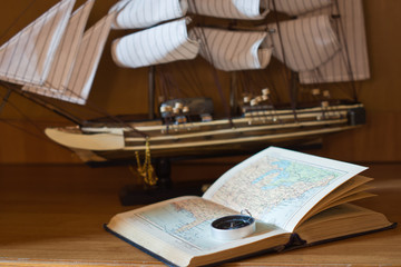 model sailing ship, map book and compass