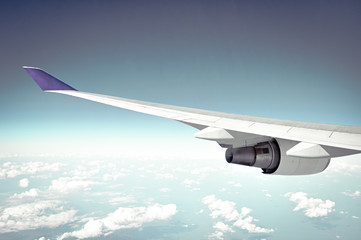 Fototapeta premium Airplane wing on blue sky background - retro lighting effect
