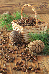 Fototapeta na wymiar Cedar nuts in a wicker basket on a wooden table