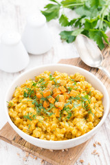 barley porridge with pumpkin and greens, top view