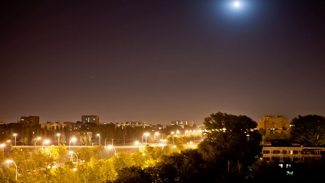 time lapse night city with a moving moon until dawn