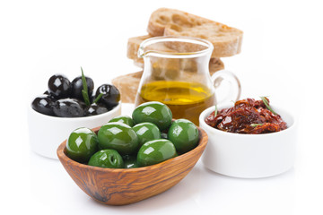 green and black olives, sun-dried tomatoes, jar with olive oil