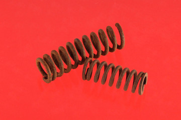 Steel spring on a red background.