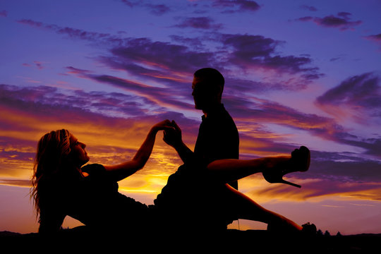 woman lay down silhouette with man hold hands