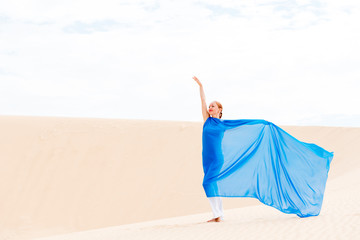 Young woman with flying blue scarf