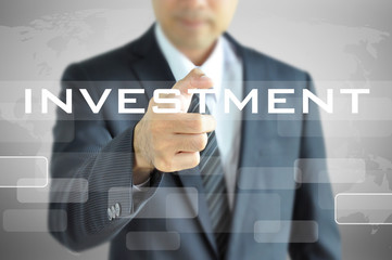 Businessman pointing to INVESTMENT word on virtual screen