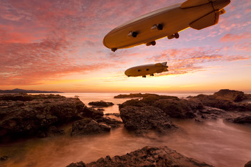 Zeppelins above rocky coast in sunset