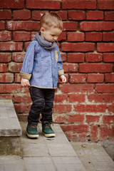 little boy walks alone on stairway