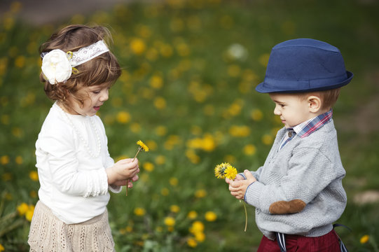cutle little boy and girl with dandelion