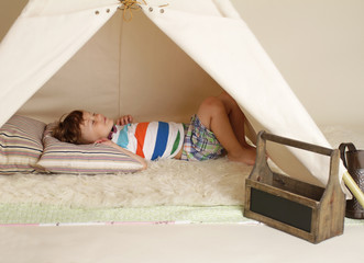 Child taking a nap in a teepee tent © chasingmoments