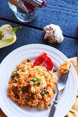 risotto with chicken and vegetables on a plate with cutlery