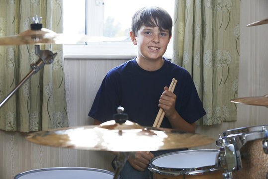 Boy Playing Drum Kit At Home