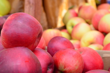 Closeup of multiple red apples for sale at an outdoor market.