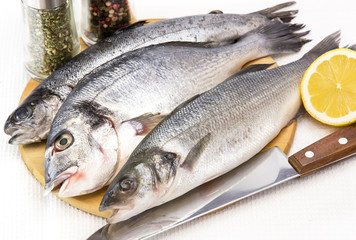 raw fish on a cutting board and knife