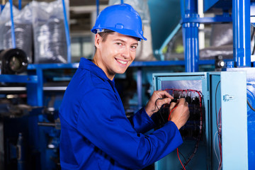 male electrician working on industrial machine