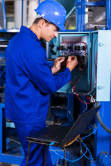 industrial engineer repairing computerized machine