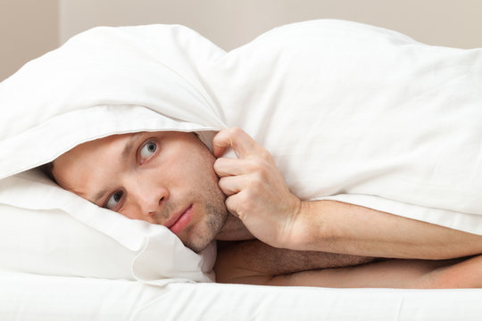 Portrait Of Funny Scared Young Caucasian Man In Bed