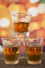 glass of rum whiskey over defocused lights background