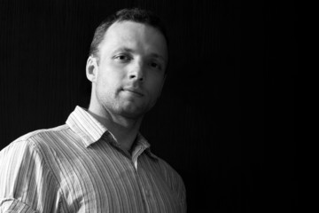 Portrait of young Caucasian man on black background