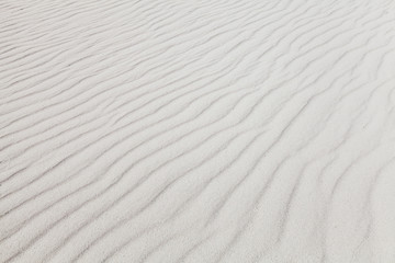White sand with wave pattern. Background photo texture