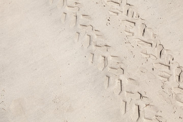 ATV tracks on the white sand beach. Closeup photo